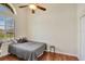 Bedroom features wood floors, arched window above a window with blinds, and ceiling fan at 13708 Old Dock Rd, Orlando, FL 32828