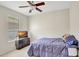 Bedroom features a ceiling fan, window with blinds, dresser, and bed with blue comforter at 13708 Old Dock Rd, Orlando, FL 32828