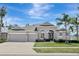 Charming single-story home featuring a three-car garage, arched entryway, and manicured landscaping at 13708 Old Dock Rd, Orlando, FL 32828