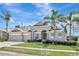 Charming single-story home featuring a three-car garage, arched entryway, and manicured landscaping at 13708 Old Dock Rd, Orlando, FL 32828