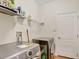 Laundry room features tile floors, washer, dryer, and wire shelf at 13708 Old Dock Rd, Orlando, FL 32828