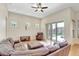 A cozy living room features a leather sectional sofa, ceiling fan, and sliding glass doors to the backyard pool at 13708 Old Dock Rd, Orlando, FL 32828