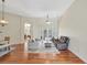 Bright and open living room with hardwood floors, neutral paint, and access to dining and patio at 13708 Old Dock Rd, Orlando, FL 32828