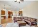 Spacious living area with a leather sectional sofa, an ottoman, and an open view to the breakfast bar and kitchen at 13708 Old Dock Rd, Orlando, FL 32828