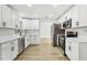 Well-lit kitchen featuring sleek, white cabinets, stainless appliances, and modern fixtures at 2791 Citron Dr, Longwood, FL 32779