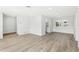 Bright, freshly painted room showcasing the wood-look flooring and access to the kitchen at 2791 Citron Dr, Longwood, FL 32779