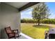 View of backyard from covered patio featuring a large tree and well-maintained lawn at 3550 Rodrick Cir, Orlando, FL 32824