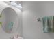 Neutral toned powder room with a round mirror and modern vanity lighting at 3550 Rodrick Cir, Orlando, FL 32824