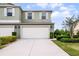 Charming two-story home with a large white garage door, well-manicured lawn and neatly trimmed hedges at 3550 Rodrick Cir, Orlando, FL 32824