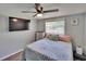 Cozy bedroom with mounted television, a ceiling fan, and a window for natural light at 4145 Willow Oak Rd, Mulberry, FL 33860