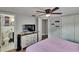 Comfortable bedroom with ensuite bathroom, ceiling fan, a television and wood-look flooring at 4145 Willow Oak Rd, Mulberry, FL 33860