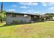 Quaint one story gray brick home, offering a covered front porch, carport, and a neatly manicured front lawn at 4145 Willow Oak Rd, Mulberry, FL 33860