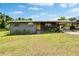 Charming single-story home with a welcoming yellow front door, lush lawn, and convenient carport at 4145 Willow Oak Rd, Mulberry, FL 33860