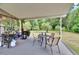Outdoor patio area with a barbecue, dining set, and views of the wooded backyard at 4145 Willow Oak Rd, Mulberry, FL 33860
