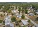 An aerial view of a quiet neighborhood showcasing a home with a large yard and mature trees at 455 W Plumosa St, Bartow, FL 33830