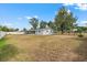 Expansive backyard with a white fence, mature trees, and a covered patio at 455 W Plumosa St, Bartow, FL 33830