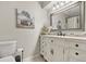 Charming bathroom with decorative white vanity, stone countertop, and framed mirror at 455 W Plumosa St, Bartow, FL 33830