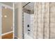 Tiled shower stall with leaf-patterned curtain and bronze-colored shower head at 455 W Plumosa St, Bartow, FL 33830