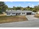 Exterior shot of a charming home with a well-manicured lawn and driveway under a bright blue sky at 455 W Plumosa St, Bartow, FL 33830