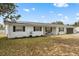 Charming brick home with fresh landscaping, dark shutters, and a inviting front porch at 455 W Plumosa St, Bartow, FL 33830