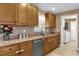 Well-lit kitchen features wood cabinets, granite countertops, mosaic backsplash, and a stainless steel dishwasher at 455 W Plumosa St, Bartow, FL 33830