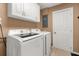 Functional laundry room featuring a modern washer and dryer set with ample cabinet storage above at 455 W Plumosa St, Bartow, FL 33830