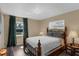 Well-lit bedroom with a wrought iron bed frame, plush bedding, and dual windows at 4727 Wales St, Lake Wales, FL 33859