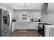 Well-lit kitchen with white cabinets, stainless steel appliances, hardwood floors, and a view of the backyard at 4727 Wales St, Lake Wales, FL 33859