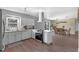 Modern kitchen featuring white cabinetry, stainless steel appliances, hardwood floors, and an open layout to the dining area at 4727 Wales St, Lake Wales, FL 33859