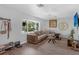 Cozy living room with a large sectional sofa, hardwood floors, and a bright window overlooking the front yard at 4727 Wales St, Lake Wales, FL 33859