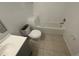 Modest bathroom with white tiling, toilet, and a tub, reflecting a clean and functional space at 6354 Sedgeford Dr, Lakeland, FL 33811