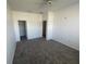 Spacious bedroom with neutral carpet, features closet and hallway access, ceiling fan, and natural light at 6354 Sedgeford Dr, Lakeland, FL 33811