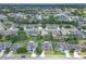 A wide aerial view showcases a neighborhood with green spaces, tree coverage, and residential homes at 6523 Evergreen Park Dr, Lakeland, FL 33813