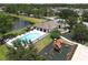 Aerial view of the community pool, clubhouse, and playground with nearby pond at 6523 Evergreen Park Dr, Lakeland, FL 33813