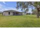 Spacious backyard featuring lush green grass, a screened-in patio, and a chain-link fence at 6523 Evergreen Park Dr, Lakeland, FL 33813