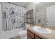Bathroom features a shower-tub combo with floral curtain and vanity sink with mirror at 6523 Evergreen Park Dr, Lakeland, FL 33813