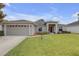 Charming single-story home featuring a well-manicured lawn, attached two car garage, and welcoming front entrance at 6523 Evergreen Park Dr, Lakeland, FL 33813