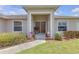Inviting front entrance with double doors, complemented by potted plants and decorative flags at 6523 Evergreen Park Dr, Lakeland, FL 33813