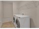Laundry room featuring tile floors, storage shelf, and a modern, front-load washer and dryer at 6523 Evergreen Park Dr, Lakeland, FL 33813