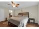 Spacious main bedroom with hardwood floors, king bed, ensuite access and a ceiling fan for a comfortable atmosphere at 6523 Evergreen Park Dr, Lakeland, FL 33813