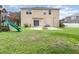 The backyard features a patio, play structure, and ample lawn space for outdoor activities at 2721 Stonewood Dr, Lakeland, FL 33810