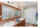 Bathroom featuring double sinks, a framed mirror, and a tub with a wave-patterned shower curtain at 2721 Stonewood Dr, Lakeland, FL 33810