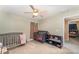 Neutral-toned bedroom with carpet flooring, offering two cribs and a toy storage bench at 2721 Stonewood Dr, Lakeland, FL 33810