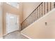 Bright entryway featuring neutral walls, tile flooring, a staircase with iron railing, and a front door with glass detailing at 2721 Stonewood Dr, Lakeland, FL 33810
