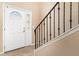 Inviting entryway featuring a classic white door with decorative glass panel and metal banister at 2721 Stonewood Dr, Lakeland, FL 33810