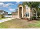 Charming two-story home with a two-car garage, arched entryway, and lush green lawn and mature landscaping at 2721 Stonewood Dr, Lakeland, FL 33810