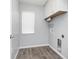 Bright laundry room featuring gray walls, wood floors, and white cabinets with utility connections at 2721 Stonewood Dr, Lakeland, FL 33810