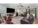 Cozy living room with a ceiling fan, leather furniture, a patterned rug, and a large television for entertainment at 2721 Stonewood Dr, Lakeland, FL 33810