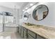 Bright bathroom featuring double sink, marble counter tops, decorative mirrors, and a jetted tub at 6442 Bendelow Dr, Lakeland, FL 33810