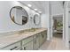 Bathroom with a double vanity, marble counter tops, modern lighting and decorative, round mirrors at 6442 Bendelow Dr, Lakeland, FL 33810